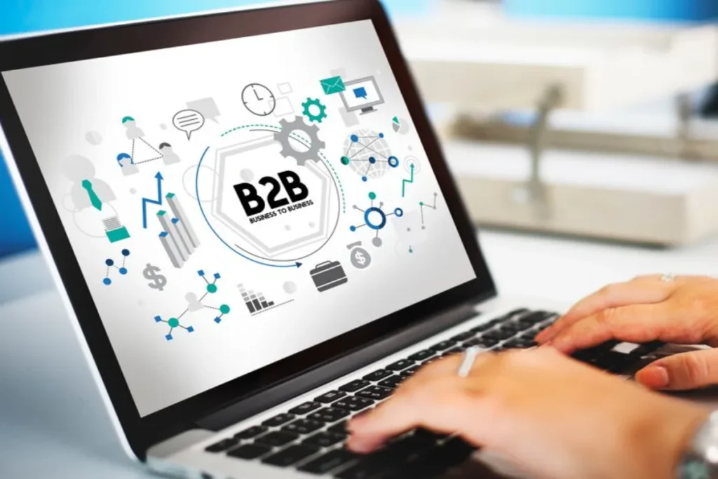 Pessoa usando notebook com ícones de processos, comunicação e negócios ligados à estruturação comercial B2B.